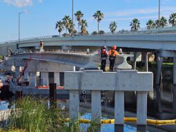 A photograph of workers installing large concrete beams for the Pinellas Trail bridge over the Tarpon Outfall Canal.