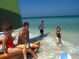 Fort De Soto beach with family playing by sailboat in gulf