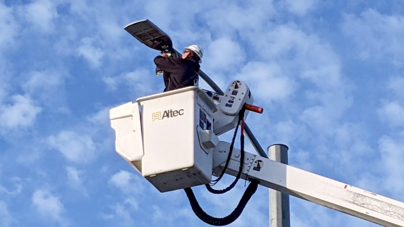 A man maintains one of Pinellas County's LED streetlights using a bucket truck
