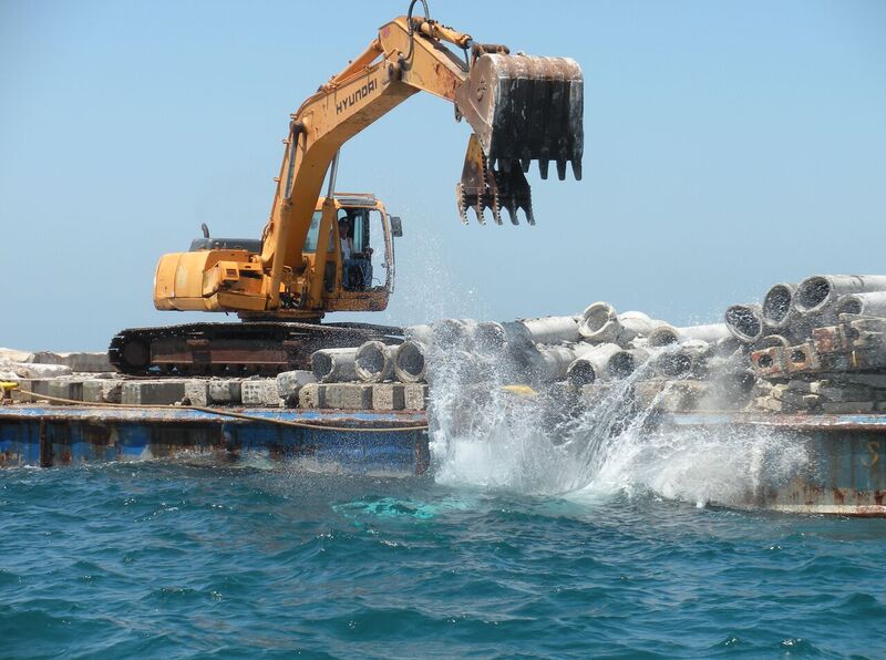 heavy equipment dropping concrete into water