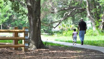 A father and daughter walking in Eagle Lake Park