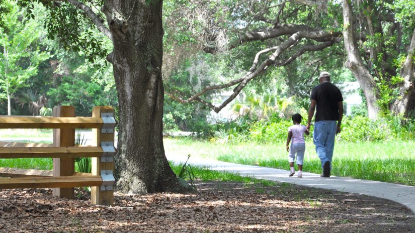 A father and daughter walking in Eagle Lake Park