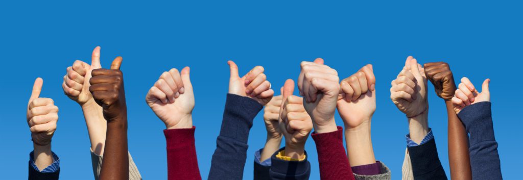 Multiracial Thumbs Up Against Blue Sky