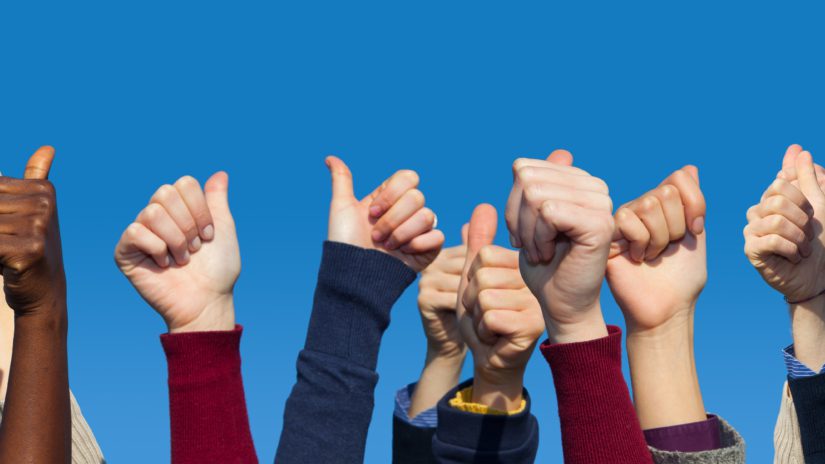 Multiracial Thumbs Up Against Blue Sky