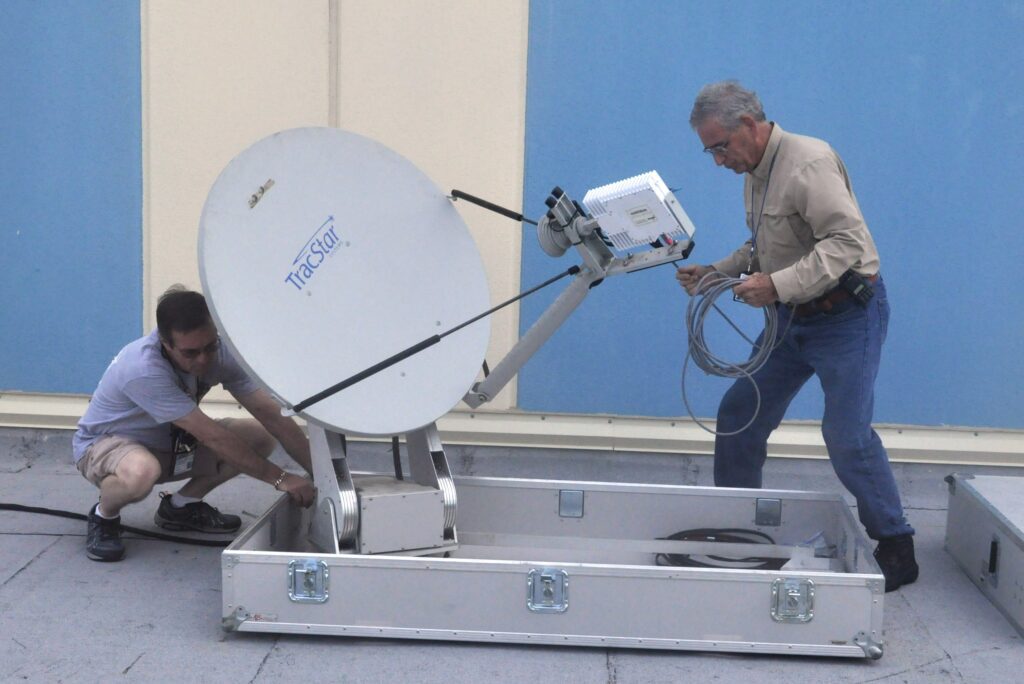 Two men setting up a satellite disk.