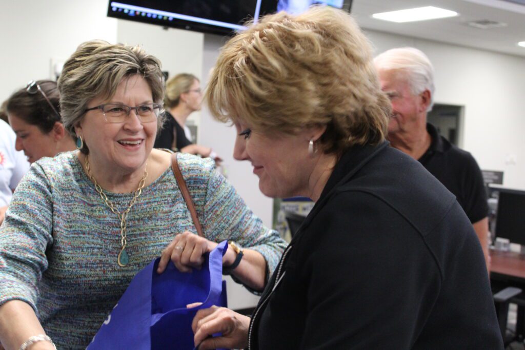 Photo of a woman giving another woman information on hurricane preparedness.