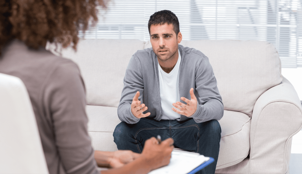 Therapist taking notes while listening to an upset patient