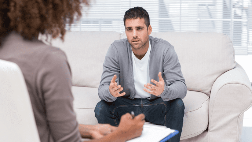 Therapist taking notes while listening to an upset patient