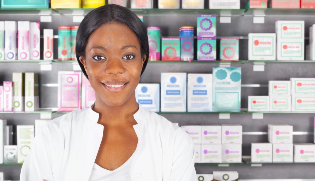 Female pharmacist in front of rows of medicines