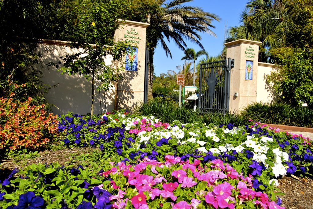 Florida Botanical Gardens entrance with colorful flowers, citrus, and palms