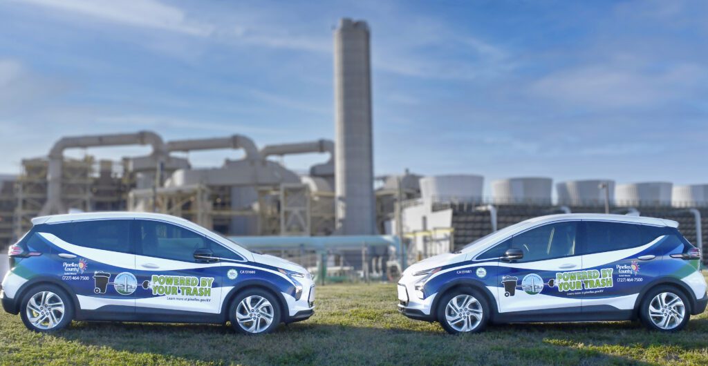 Photo of Pinellas County's two 2021 Chevrolet Bolt electric vehicles in front of the Pinellas County Waste-to-Energy facility