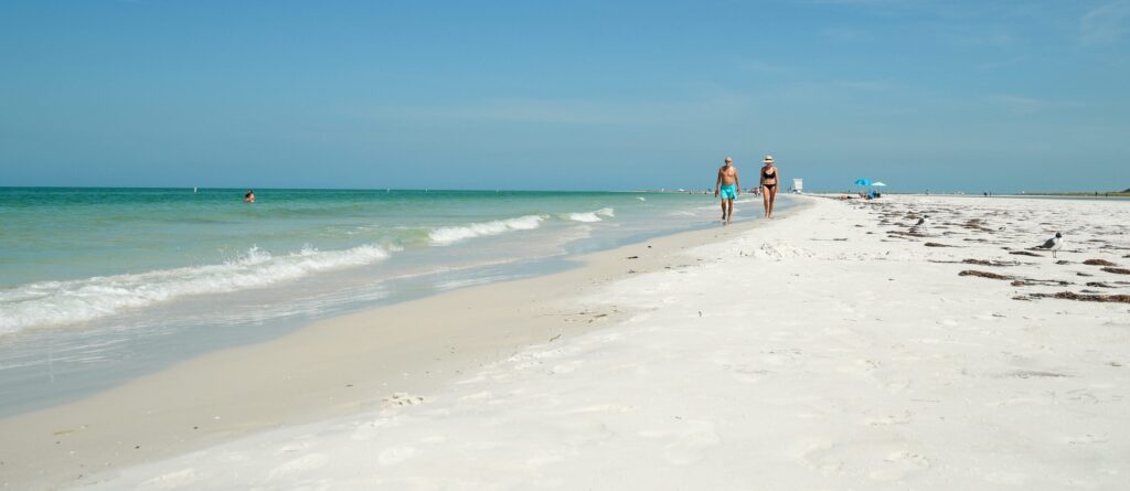 People enjoy blue skies at the beach