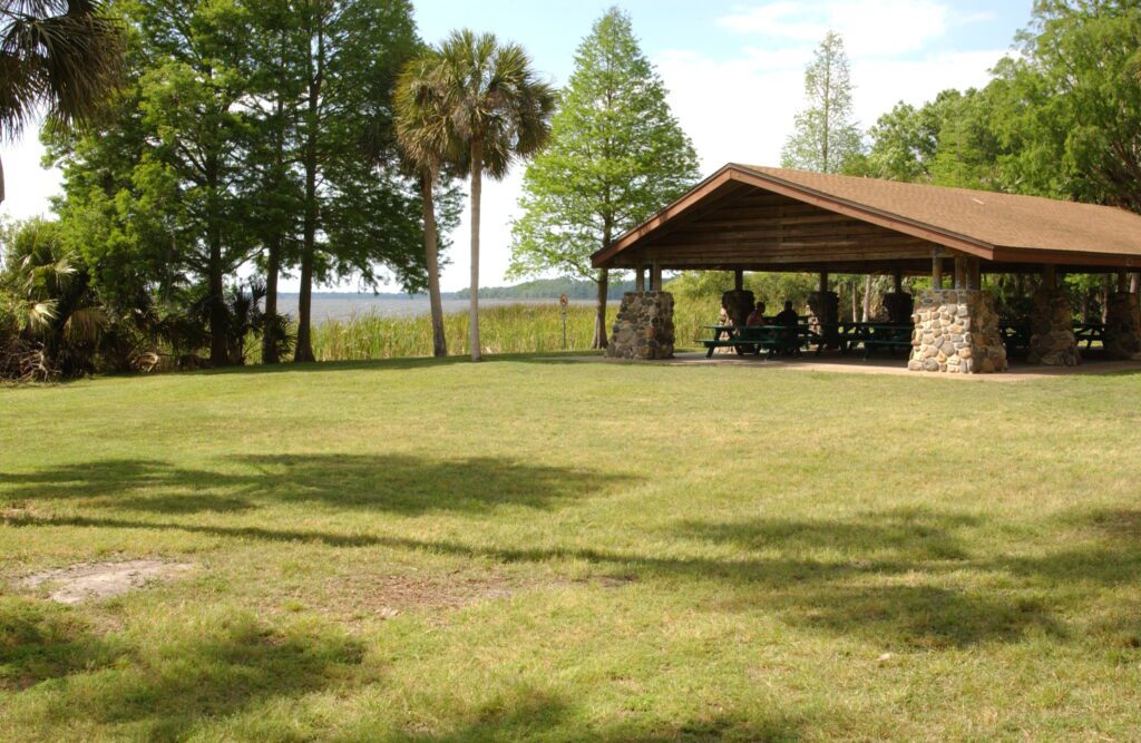 park visitors enjoy the shade of a picnic shelter at John Chesnut park