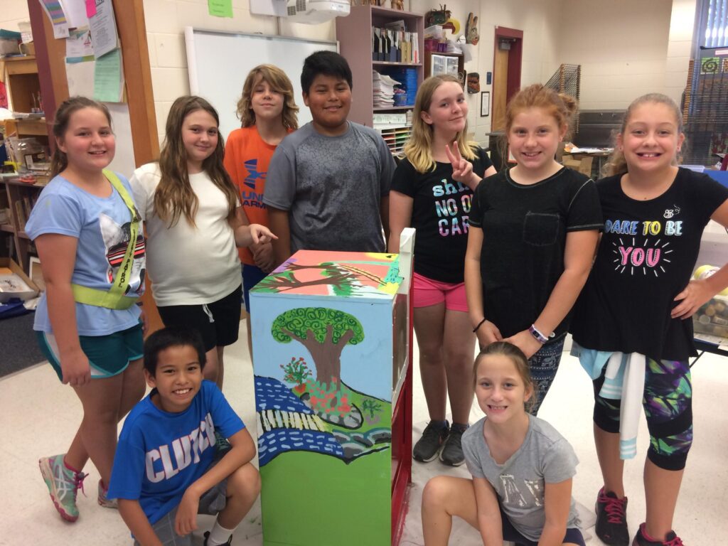 Kids posing with a painted mailbox inside the Lealman Exchange. 