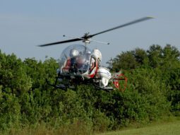 a helicopter sprays for mosquitos