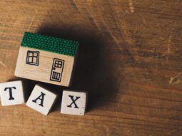 House model with tax word made from wooden blocks