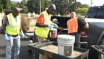 County workers collecting residents drive-thru chemicals from Solid Waste mobile collections event at St. Pete College