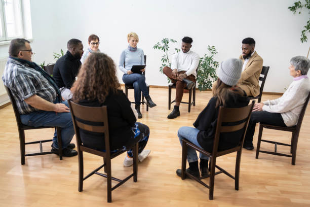 Meeting for mental health group therapy sitting in a circle in a modern mental health facility