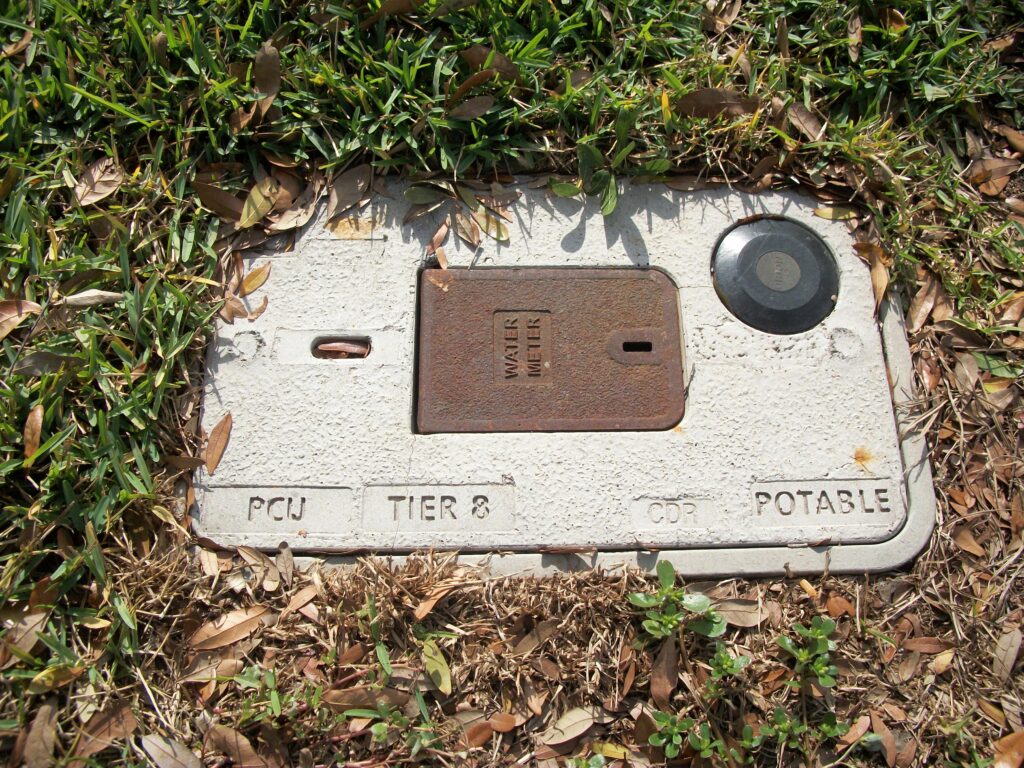 Potable water meter box in the ground.
