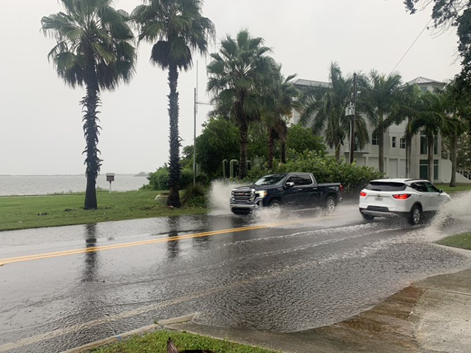 Cars driving on flooded coastal street