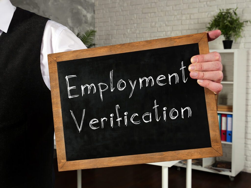 Person holding a mini blackboard with Employment Verification written on it.