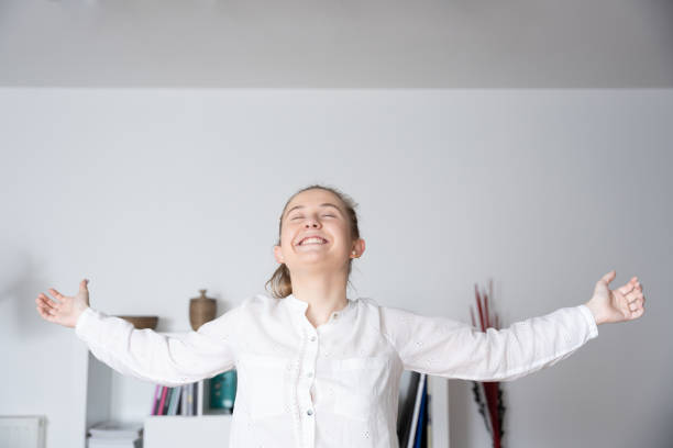 Young happy woman celebrating financial freedom or good news with open arms.