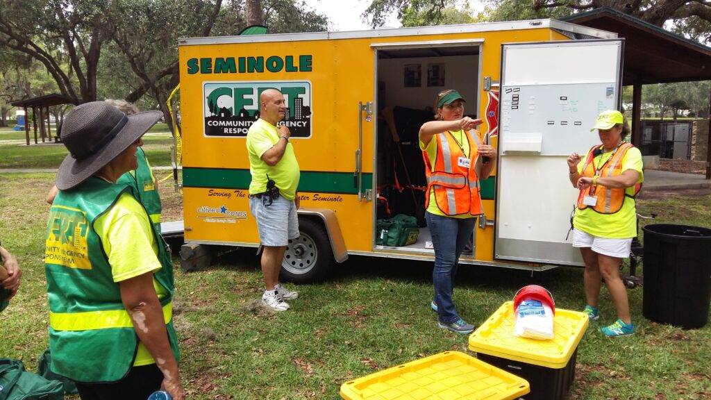 Members of the Seminole Community Emergency Response Team stand in front of a truck as one member gives instructions.