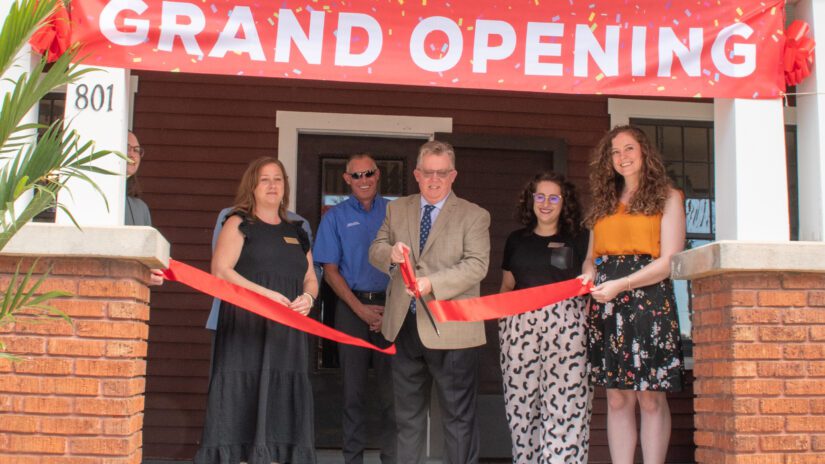 Commissioners and Heritage VIllage staff cut the ribbon to officially open the Turner Bungalow.