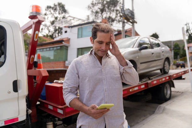 Man having problem with his car and calling roadside assistance to take his vehicle to the auto repair shop - roadside assistance concepts