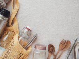 Image of reusable items such as a bag, bottle, straw, and cutlery set.