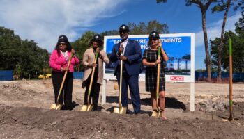 County and city elected officials hold shovels at a groundbreaking for Bayou Court Apartments in St. Petersburg.