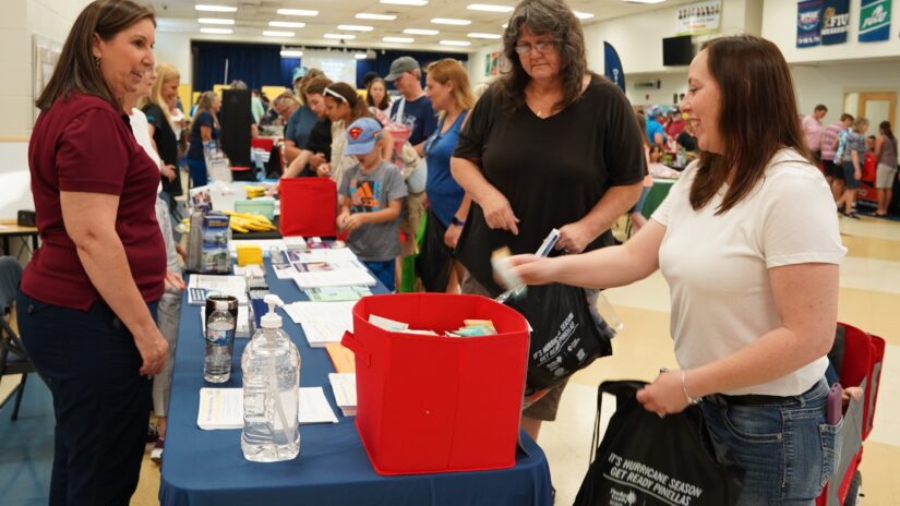 Attendees pick up giveaways from a table at the 2023 Pinellas County Hurricane Preparedness Expo