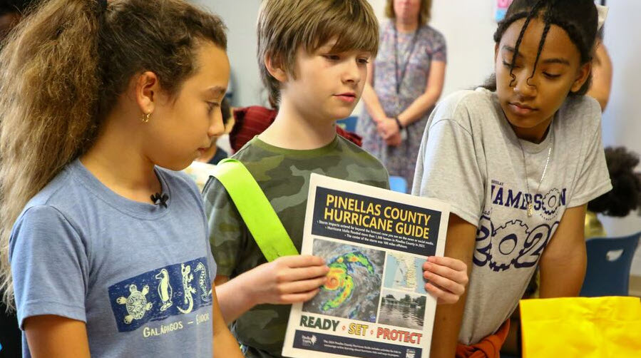 Photo of three children holding up the Pinellas County Hurricane Guide.