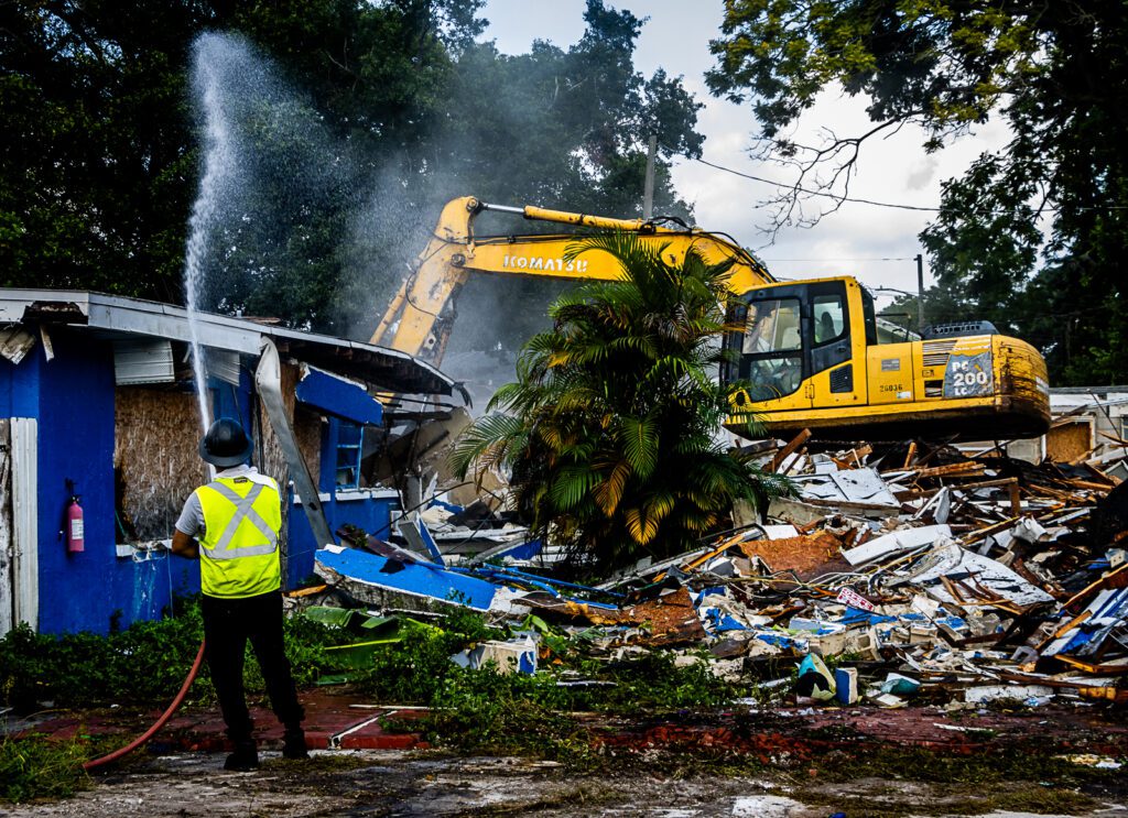 A man with a fire hose as the Blue House is demolished