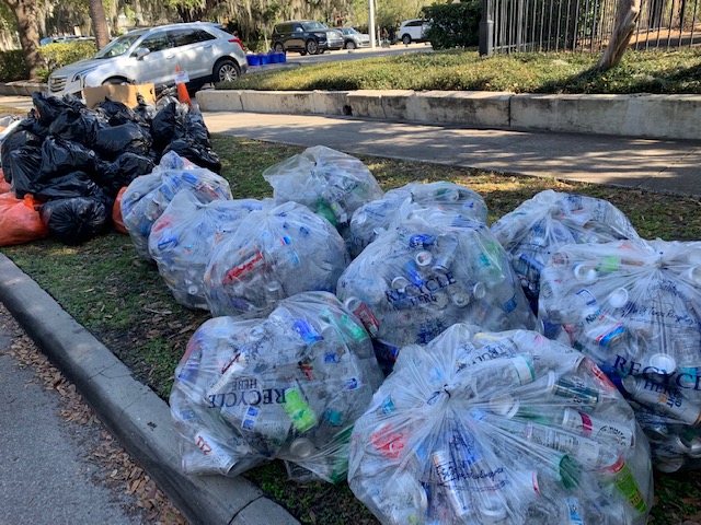 Bags of recyclables and trash on the curb.