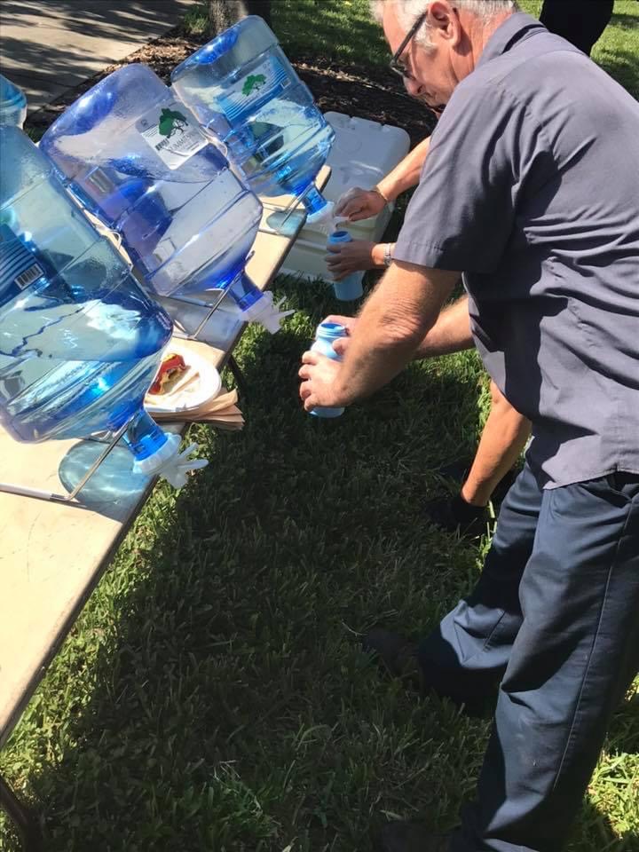 Person refilling water bottle at a refill station.