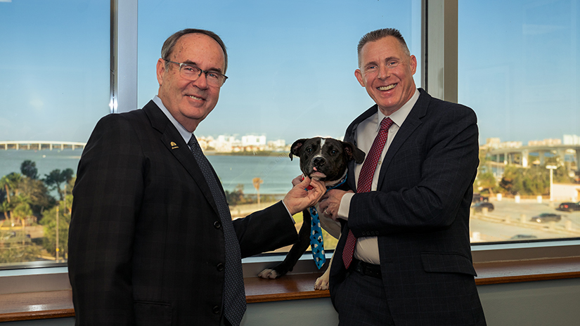 Commissioners Eggers and Scott meet one of the adoptable dogs available through Animal Services.