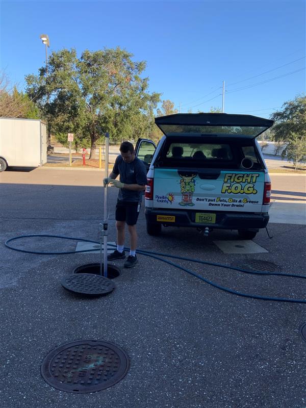 Pinellas County employee monitoring grease in sewer system.
