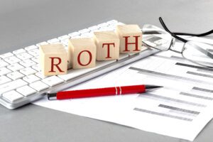 Keyboard, wooden blocks spelling ROTH, pencil, paper with graphs, eyeglasses