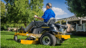 County employee cutting grass next to a house with a hustler mower