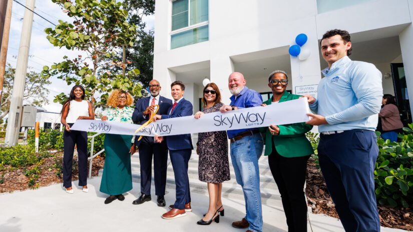 Officials lined up to the cut the ribbon on the SkyWay Lofts apartments.