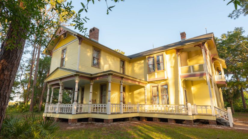 Photo of a yellow, two story house . Originally built in 1907, the house is on display at Heritage Village in Largo, Florida.