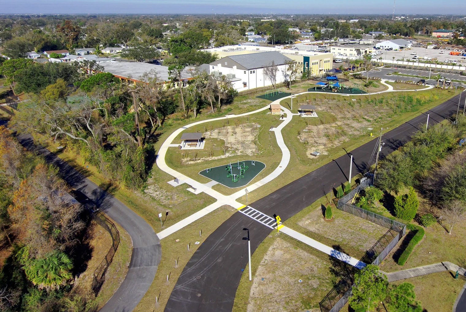 aerial view of Raymond H Neri park showing playground, outdoor workout equipment, walking trail, picnic shelter, and open space.