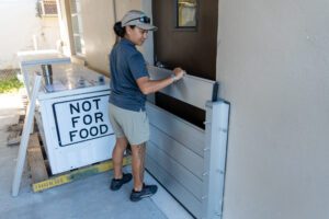 Women puts a flood barrier over a door.