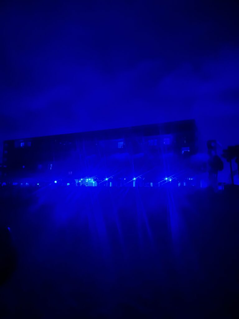 A beachfront condominium is lit up at night on Indian shores. The filtered image approximates how a sea turtle would perceive it. The white lights at the bottom are bright, while other lights in the building are not visible.