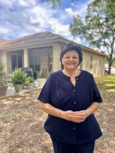 Pinellas homeowner Martha Cannon poses in front of her home as restoration work begins.