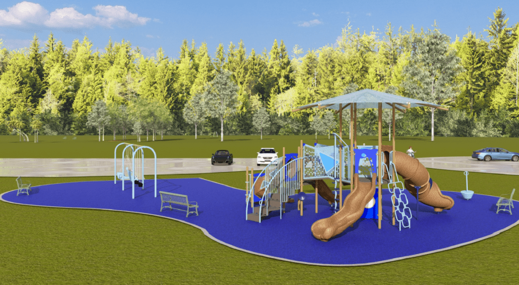 The image shows an outdoor playground built on a bright blue rubberized safety surface with a smooth, curved outline. The playground is set in a large grassy field surrounded by tall trees with dense green foliage. In the background, a paved roadway runs behind the playground, with several vehicles visible.
The right side of the playground features a multi‑level play structure with several interconnected platforms, railings, and activity components. The structure includes two brown slides—a straight slide in front and a curved tube slide on the right side. A staircase with handrails leads up to one of the platforms. A large, square-shaped canopy supported by tall posts provides shade over the structure. Additional climbing elements, such as a geometric ladder made of metal loops, are attached to the play area.
To the left of the play structure is a swing set with a light‑blue metal frame. The swing bay includes two belt swings and two molded adaptive swings with high‑back supportive seats. In front of the swing area, a green metal bench faces the playground. Another small spinning bowl element is positioned on the far left side of the play surface.
The lighting is bright, suggesting a sunny day with a clear blue sky.