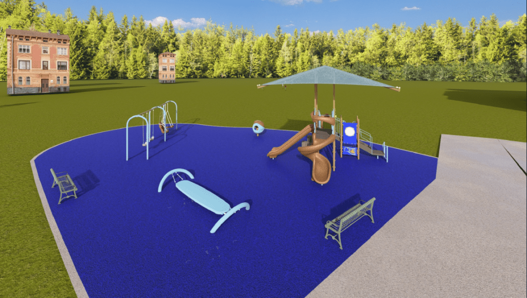 The image shows an outdoor playground installed on a bright blue rubberized safety surface with an irregular curved shape. The playground is set in a large grassy open area bordered by tall, dense green trees. Two multi‑story brick buildings are visible in the distance.
On the right side of the playground is a multi‑level play structure with several connected platforms, railings, and play panels. A large square shade canopy supported by tall posts covers the central portion of the structure. The play equipment includes two brown slides: one straight slide extending toward the front and one spiral slide wrapping toward the right side. A metal staircase with handrails provides access to the elevated platform.
Near the center of the play area, an upright circular play element is mounted on a single pole. To the left of the main structure are a small swing set with two belt swings and a toddler bucket swing. A curved metal balance or rocking structure is positioned in the foreground.
Two green metal benches are located on opposite sides of the playground—one on the left side near the swings and one on the right side near the play structure. A concrete walkway borders the playground on the far right edge.
The sky is bright blue with a few scattered clouds, indicating clear, sunny weather.