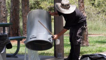Pinellas County mosquito control staff dumps out standing water from trash can