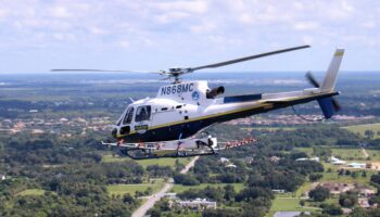 Image of Lee County Mosquito Control helicopter flying above community.